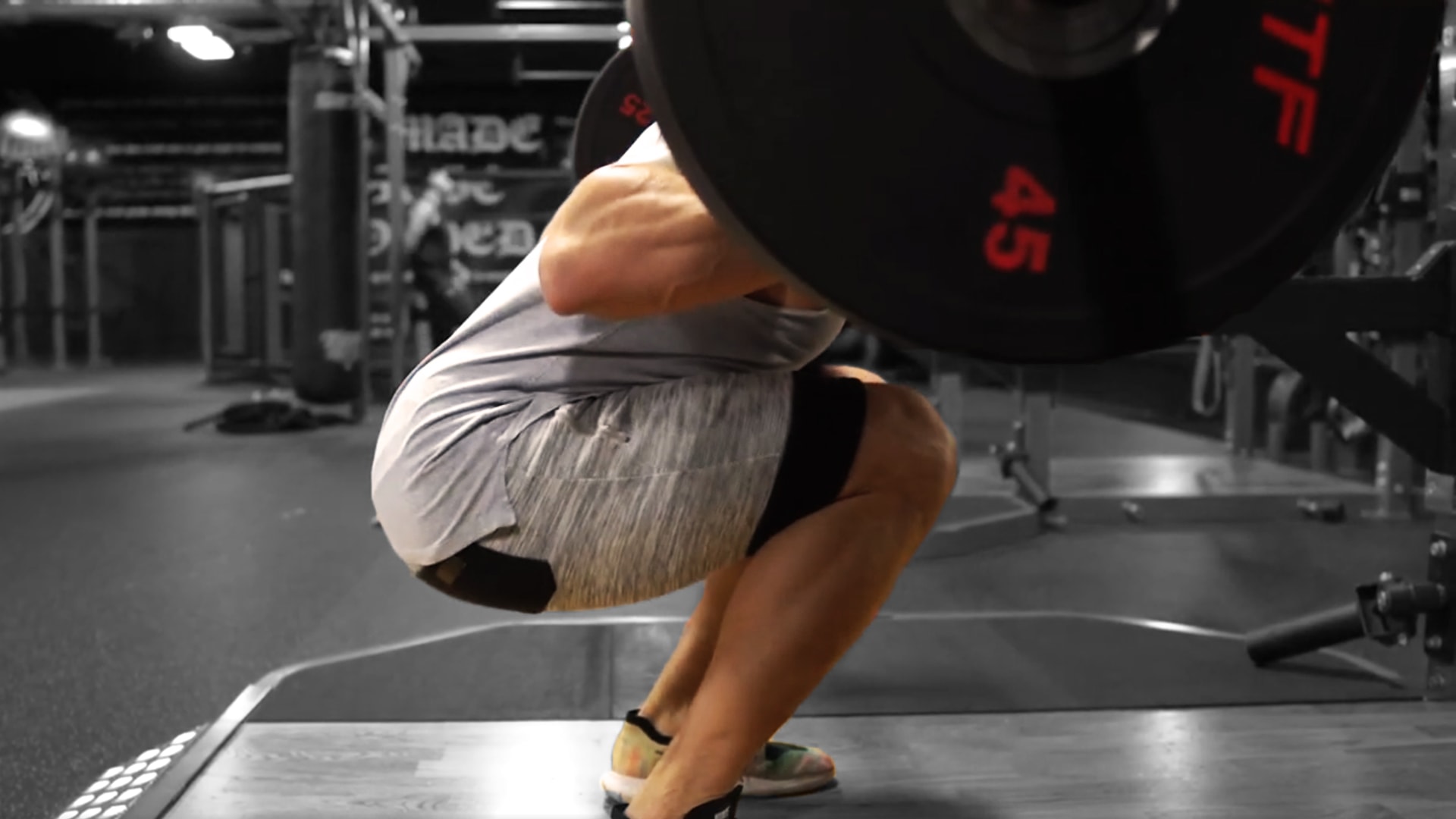 Troy performing a barbell squat exercise at the gym