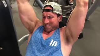 Troy performing a seated overhead press at the gym