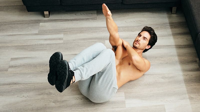 adult man training abs muscles at home