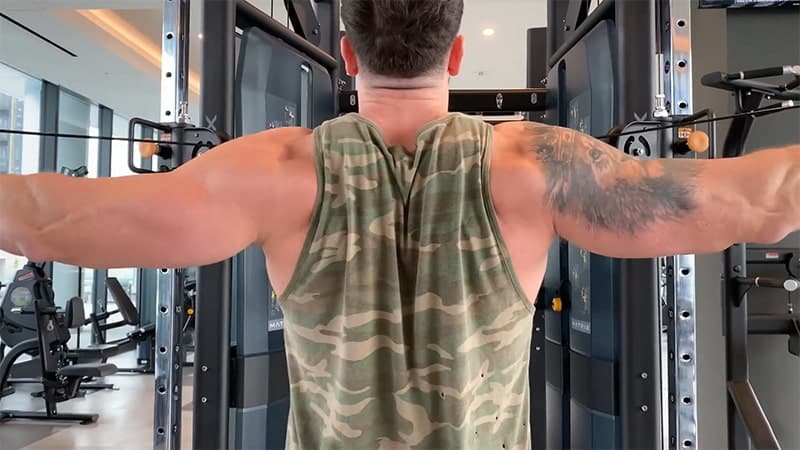 close up of Troy performing a cable rear delt fly at the gym