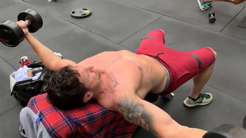 Troy performing a flat bench dumbbell fly