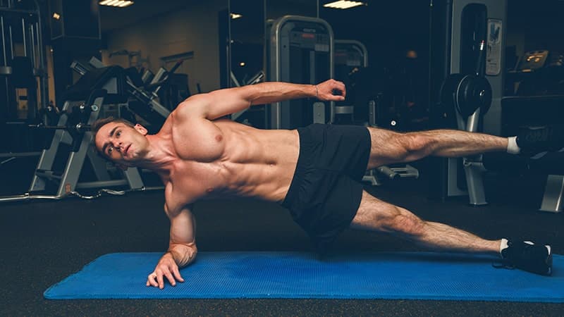 sportive young man doing side plank