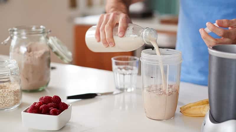 close up of man making protein shake after exercising