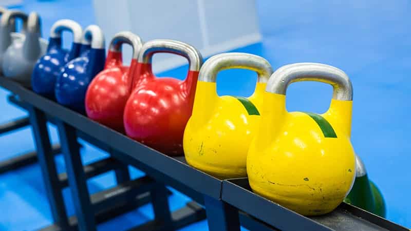 colorful kettlebells in a row in a gym